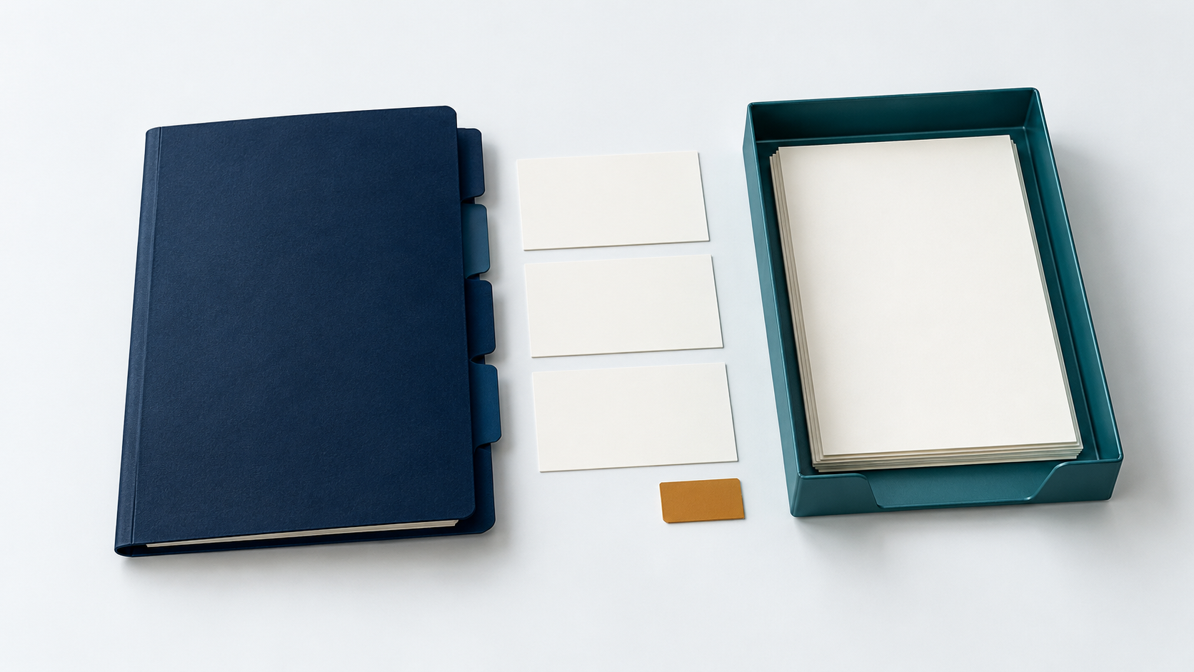 A navy tabbed folder, blank record cards, a teal document tray and a small amber tab on an off-white desk.